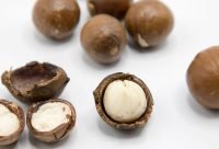 Nueces de macadamia sobre superficie blanca